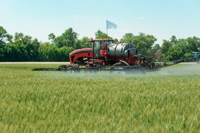 Tractor in an open field spraying pest control